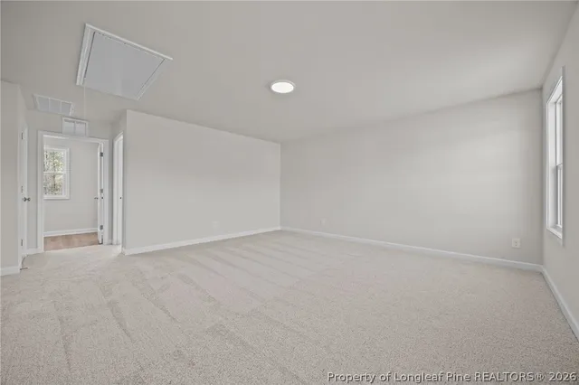 an empty room with wooden floor fireplace and fan