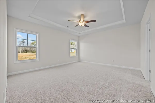 a view of an empty room with a window and fireplace