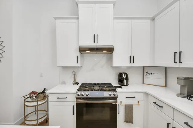 a kitchen with granite countertop a stove and a sink