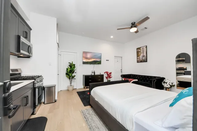 a bedroom with a bed a flat screen tv and dresser