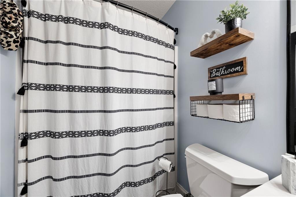 6 Keystone Lane Northeast Rome, GA 30161 - Photo 17 of 26 a bathroom with a toilet and a shower curtain