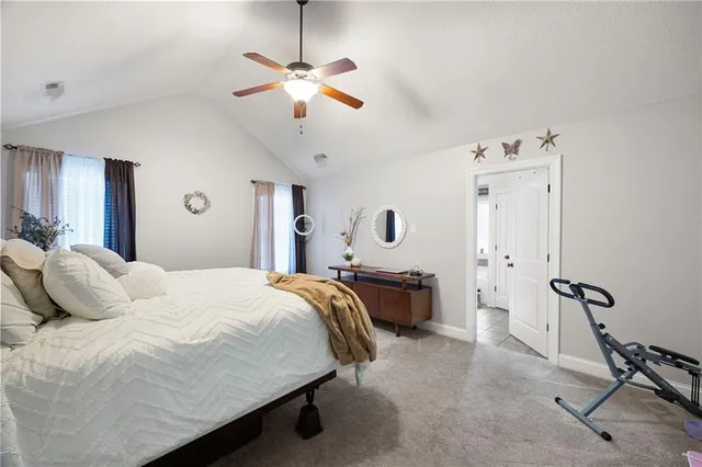 a spacious bedroom with a bed and a chandelier