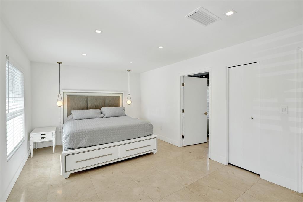 701 Northeast 164th Street Miami, FL 33162 - Photo 24 of 52 a spacious bedroom with a bed and a window