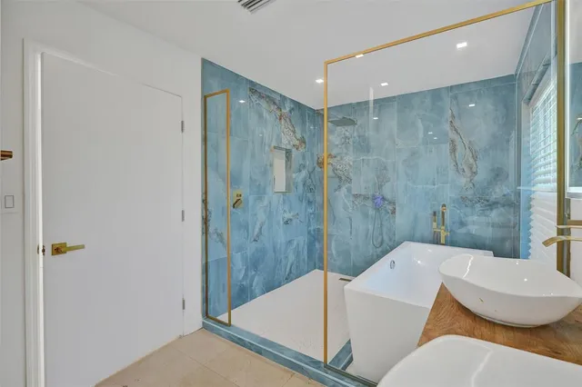 a bathroom with a sink and mirror with bathtub
