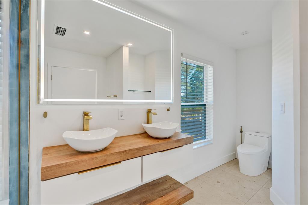701 Northeast 164th Street Miami, FL 33162 - Photo 28 of 52 a bathroom with a granite countertop sink and a mirror