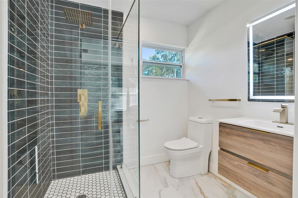 701 Northeast 164th Street Miami, FL 33162 - Photo 35 of 52 a bathroom with a toilet a sink and a shower