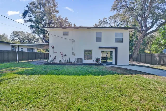 a view of a house with backyard and a tree