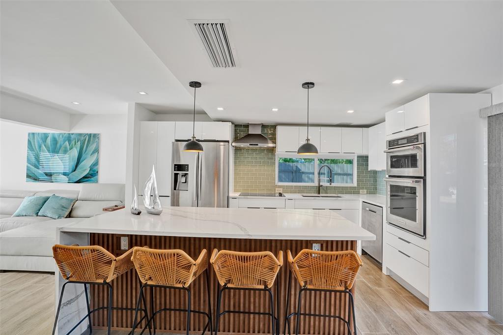701 Northeast 164th Street Miami, FL 33162 - Photo 5 of 52 a kitchen with stainless steel appliances granite countertop a kitchen island a stove and a sink