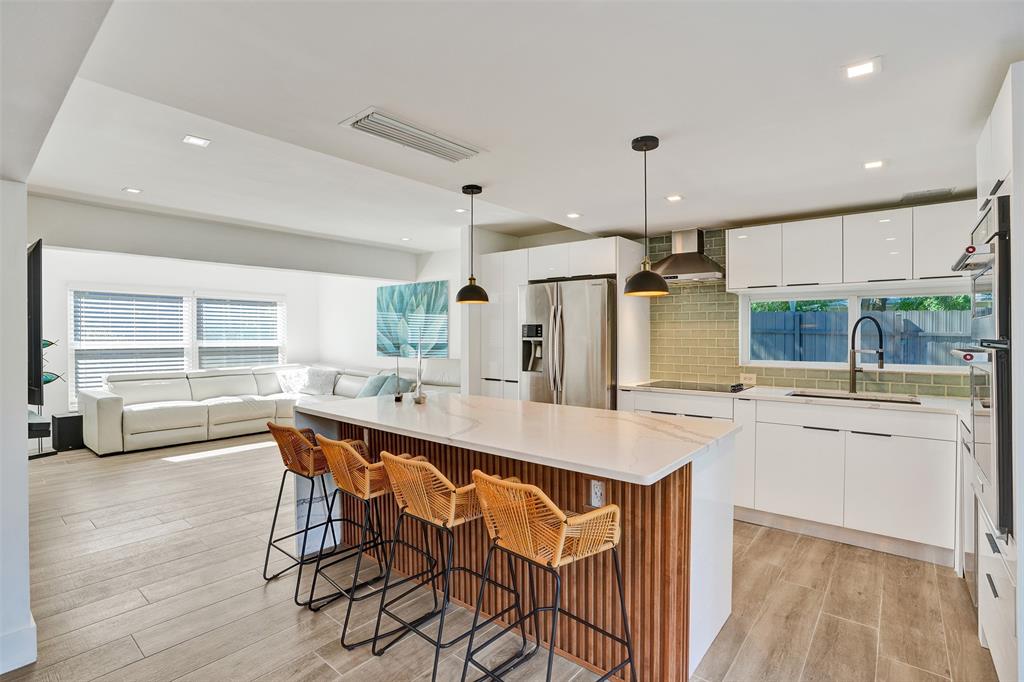 701 Northeast 164th Street Miami, FL 33162 - Photo 6 of 52 a kitchen with stainless steel appliances a dining table chairs and white cabinets