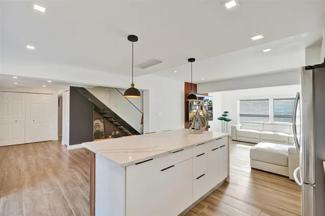 a view of a kitchen with kitchen island a sink stainless steel appliances and cabinets