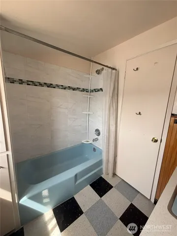 a bathroom with a bathtub and a shower