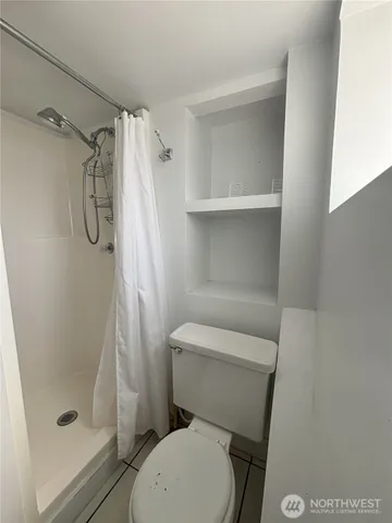 a white toilet sitting next to a shower