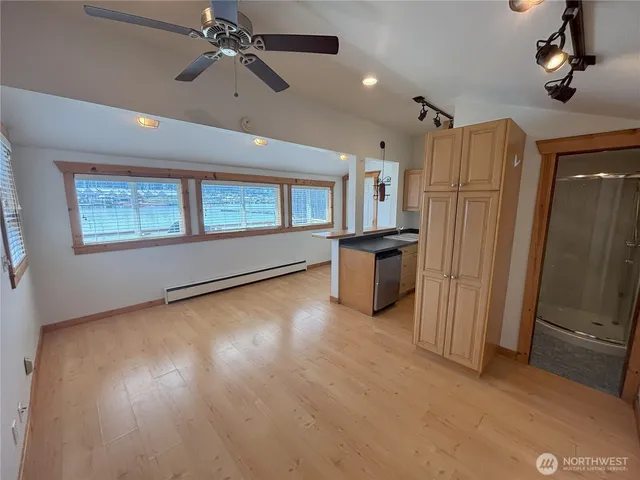 an empty room with windows cabinet and a kitchen