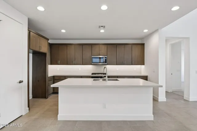 a large kitchen with stainless steel appliances granite countertop a sink a stove and a refrigerator