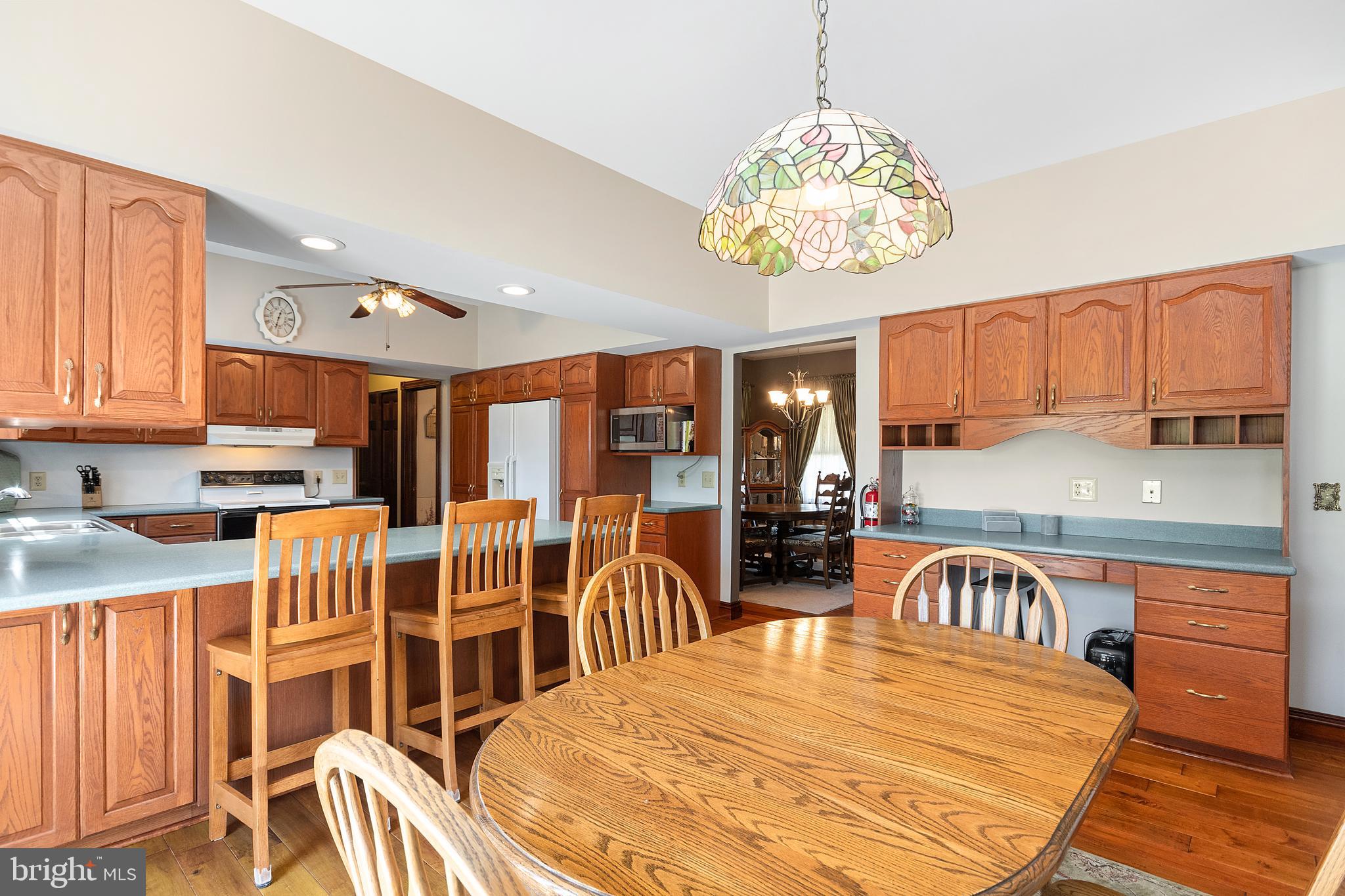 487 Radix Road Williamstown, NJ 08094 - Photo 8 of 36 a open kitchen with stainless steel appliances granite countertop a stove a refrigerator a kitchen island a dining table and chairs with wooden floor