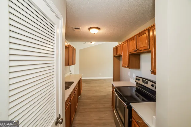 a kitchen with granite countertop a sink and a stove top oven