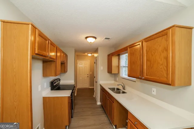 a kitchen with stainless steel appliances a sink a stove and a refrigerator