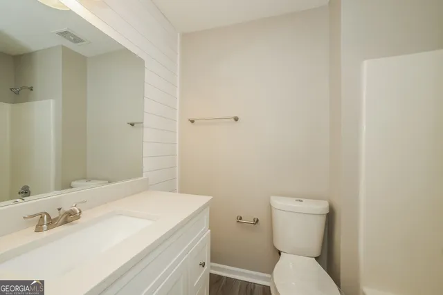 a bathroom with a sink a toilet and a mirror