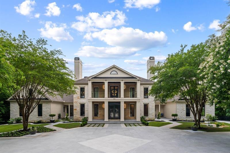 a front view of a house with a garden and trees