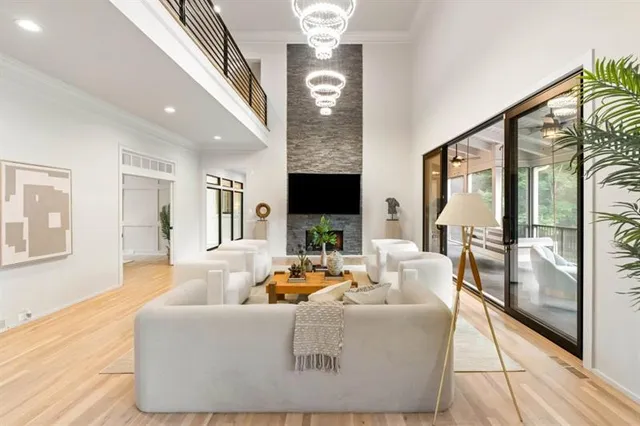 a living room with furniture a chandelier and a floor to ceiling window