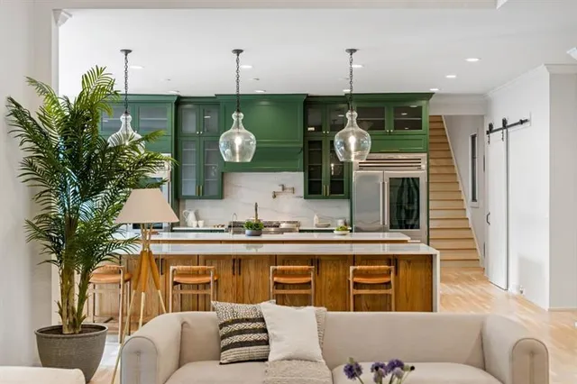 a open kitchen with stainless steel appliances granite countertop a stove a refrigerator and a wooden floors