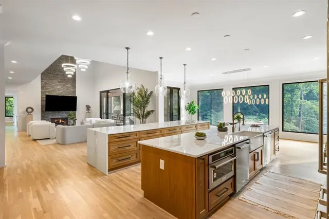 a kitchen with stainless steel appliances granite countertop a sink a stove and a wooden floors