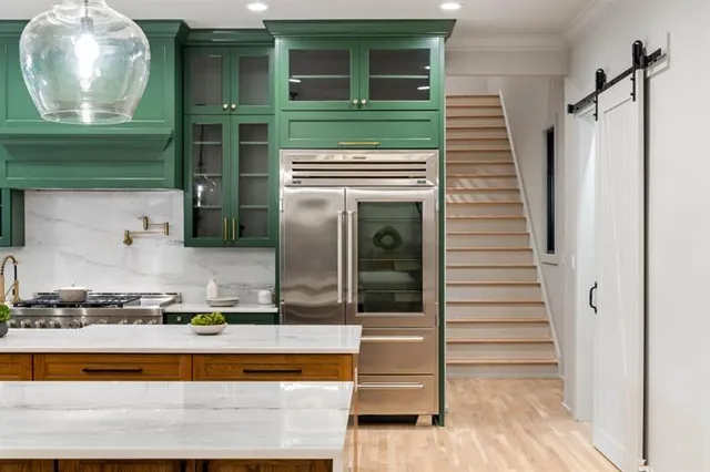 a kitchen with stainless steel appliances kitchen island granite countertop a table and chairs in it