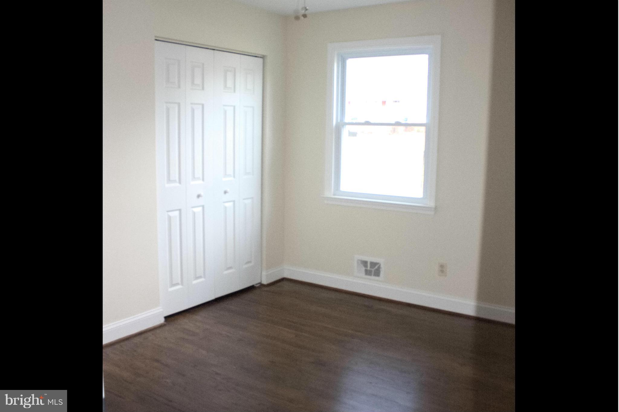 6709 Garvey Road Baltimore, MD 21237 - Photo 13 of 29 an empty room with wooden floor and windows