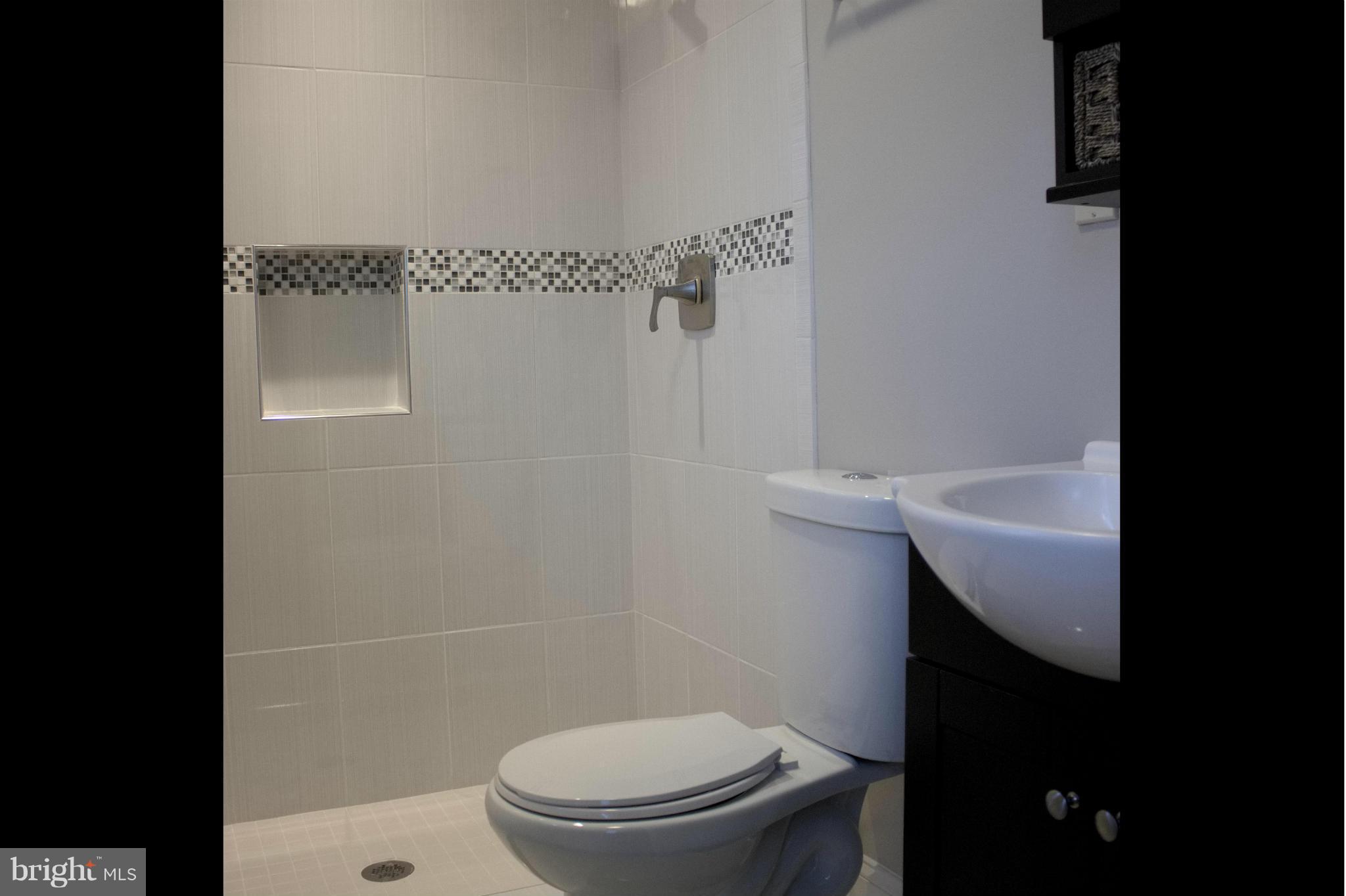 6709 Garvey Road Baltimore, MD 21237 - Photo 14 of 29 a bathroom with a sink a toilet and a shower