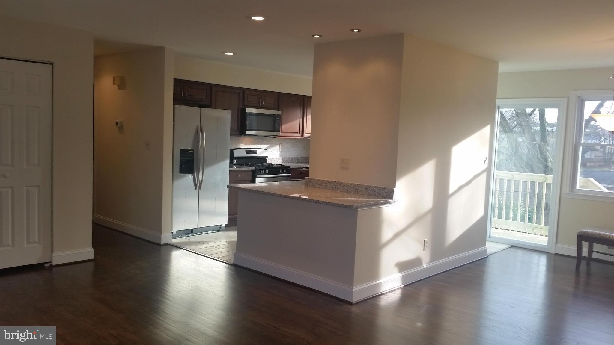 6709 Garvey Road Baltimore, MD 21237 - Photo 4 of 29 a kitchen with stainless steel appliances a refrigerator and wooden floor
