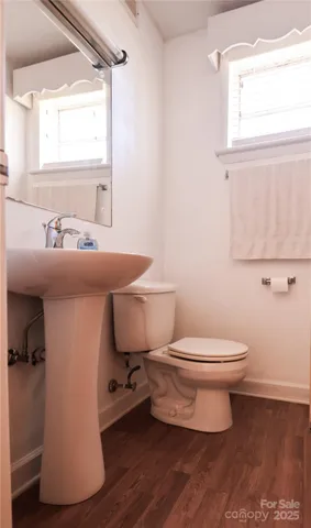 a bathroom with a sink toilet and a window