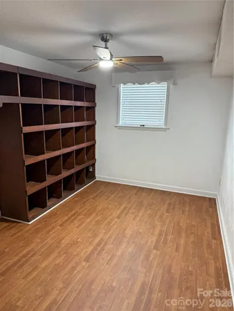 a view of an empty room with a fireplace and a bookshelf