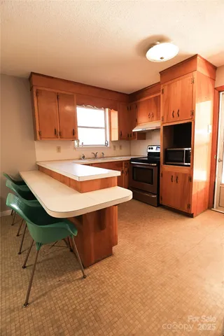 a kitchen with stainless steel appliances kitchen island granite countertop a sink and a stove