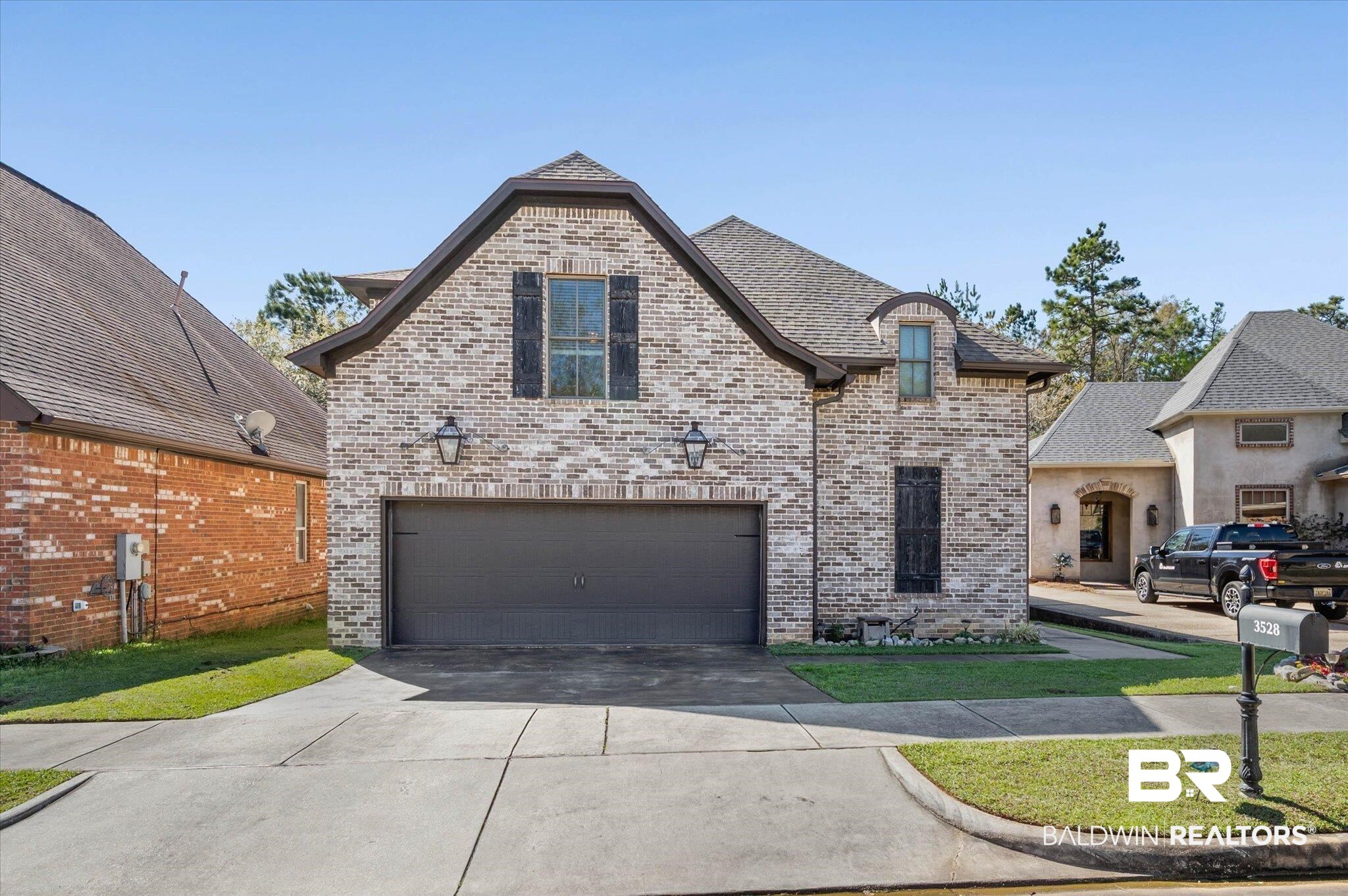 3528 Rue Royal Mobile, AL 36693 - Photo 2 of 53 French country inspired facade with brick siding, concrete driveway, and a garage