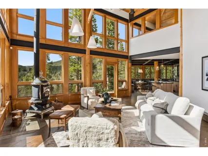 a living room with furniture and floor to ceiling windows