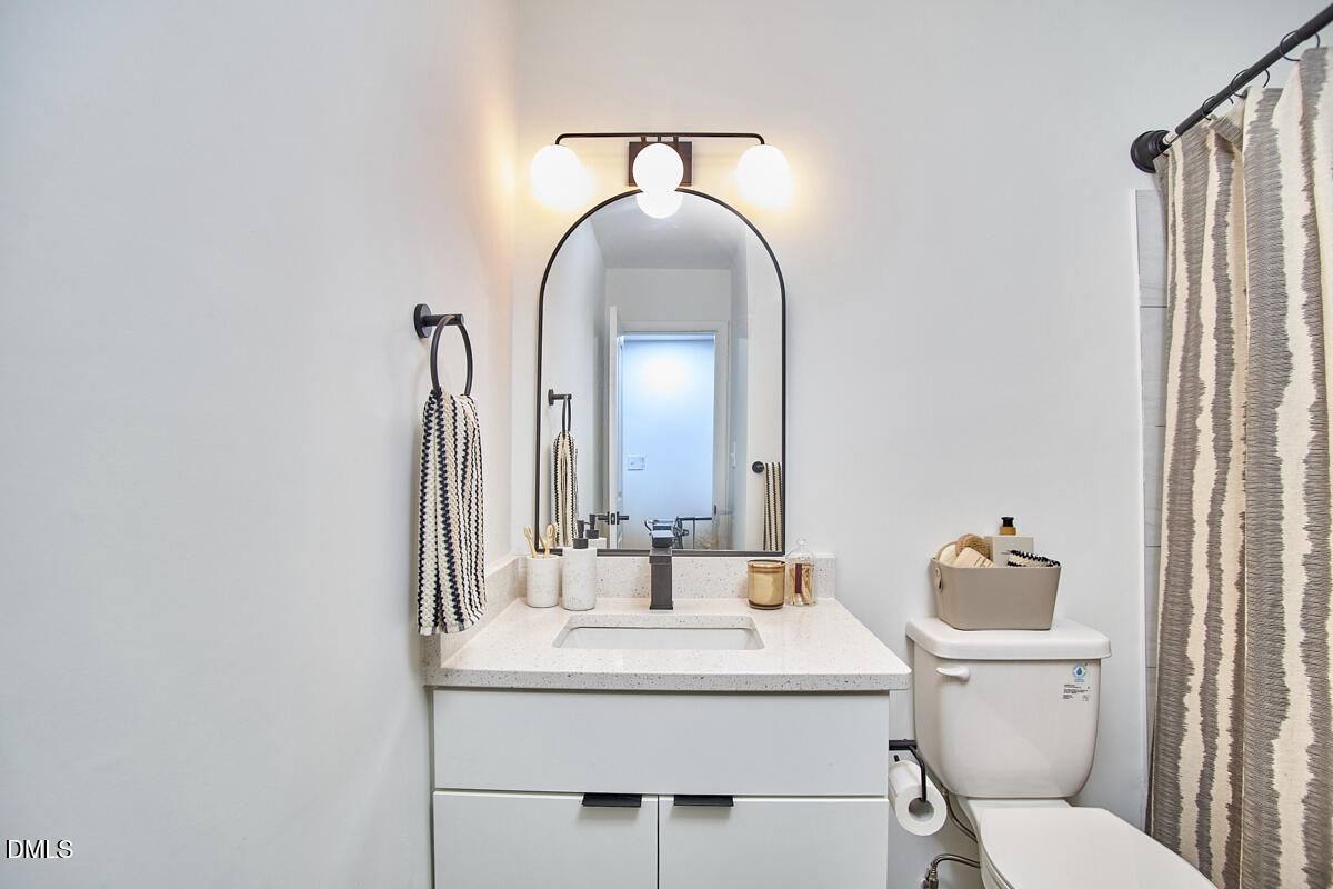 2613 McNeil Street, Unit E Raleigh, NC 27608 - Photo 22 of 28 a bathroom with a toilet sink and mirror