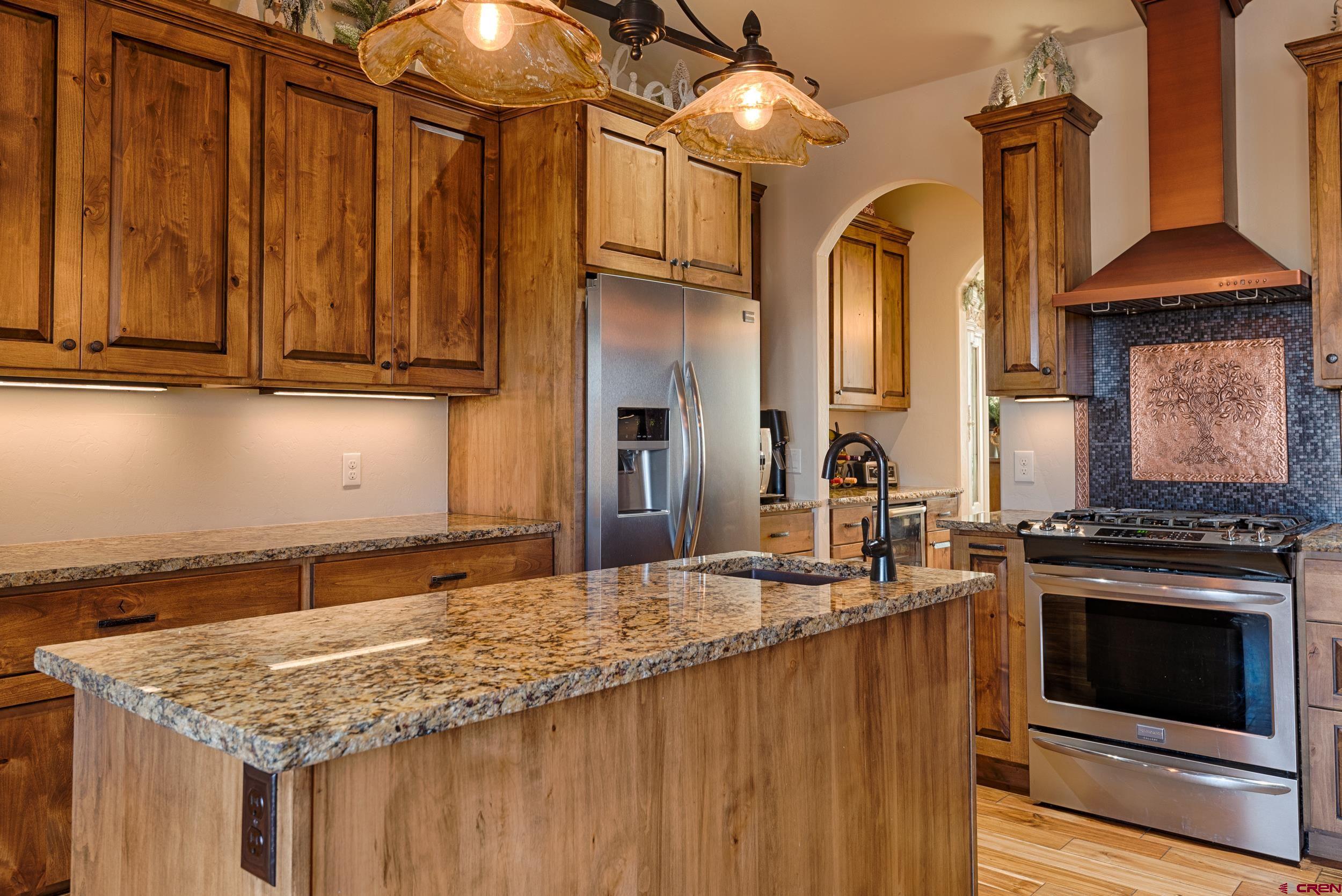 13287 6160th Road Montrose, CO 81403 - Photo 15 of 35 a kitchen with stainless steel appliances granite countertop a stove a sink dishwasher and cabinets with wooden floor