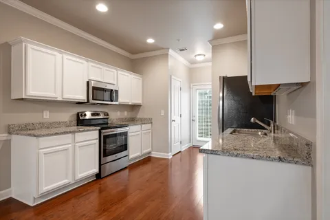 a kitchen with stainless steel appliances granite countertop a stove a sink and a refrigerator