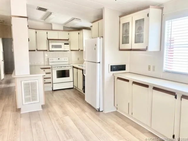 a kitchen with white cabinets and white appliances