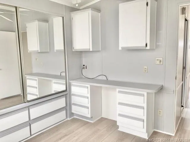 a kitchen with white cabinets and a window