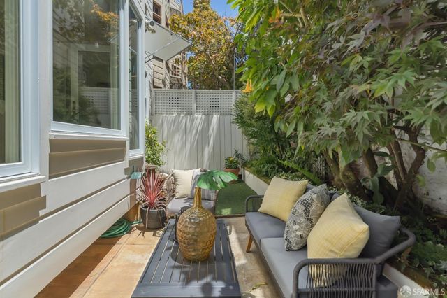 a balcony with chairs and with potted plants