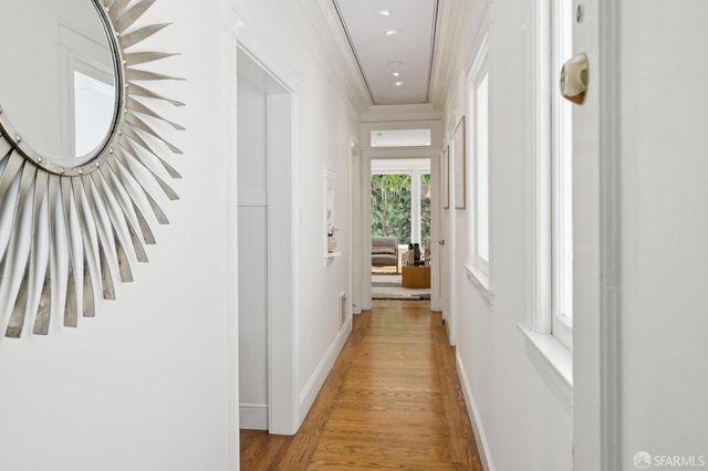a view of a hallway with wooden floor and glass door