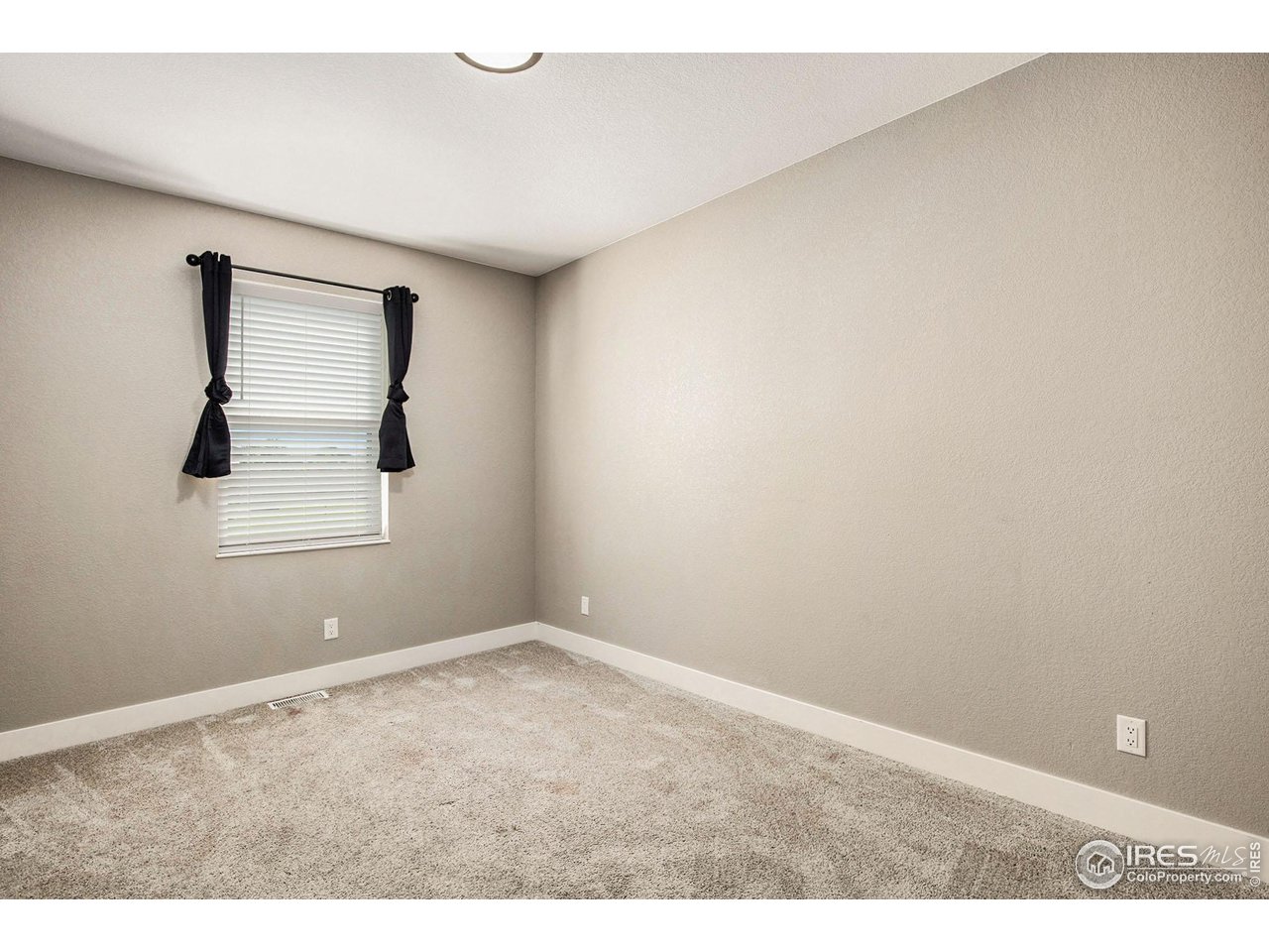 1100 Johnson Street Wiggins, CO 80654 - Photo 18 of 34 an empty room with windows and closet