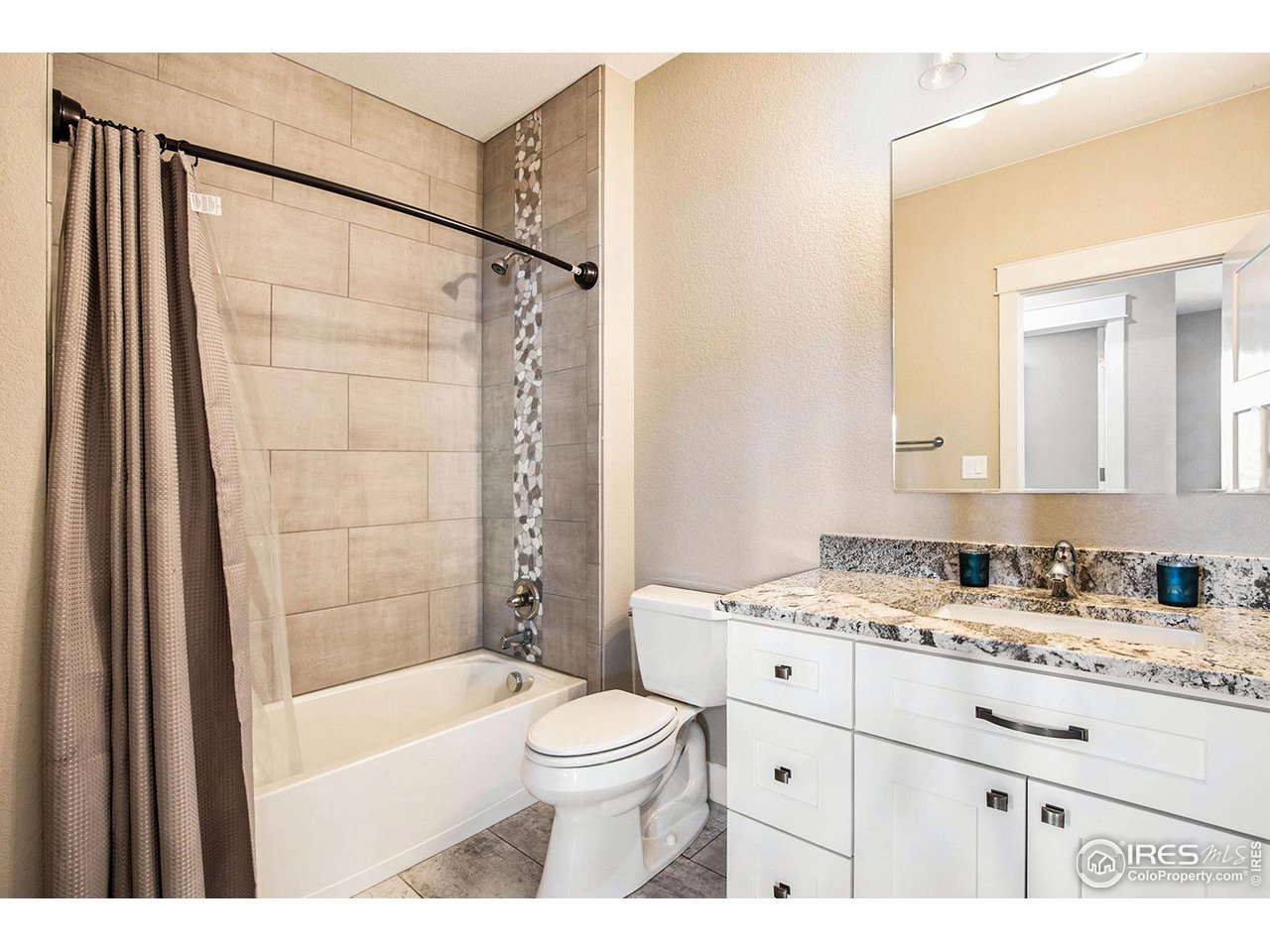 1100 Johnson Street Wiggins, CO 80654 - Photo 20 of 34 a bathroom with a granite countertop sink toilet a mirror and shower