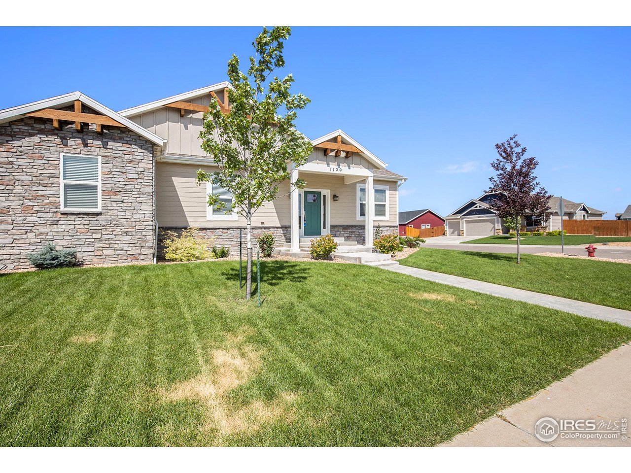 1100 Johnson Street Wiggins, CO 80654 - Photo 24 of 34 a front view of a house with a yard and garage