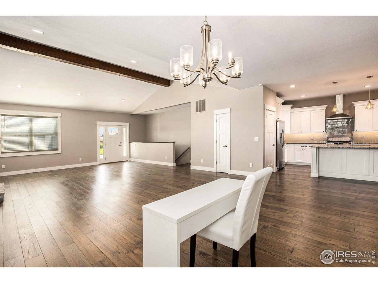 1100 Johnson Street Wiggins, CO 80654 - Photo 4 of 34 a view of a dining room and livingroom with furniture wooden floor a chandelier