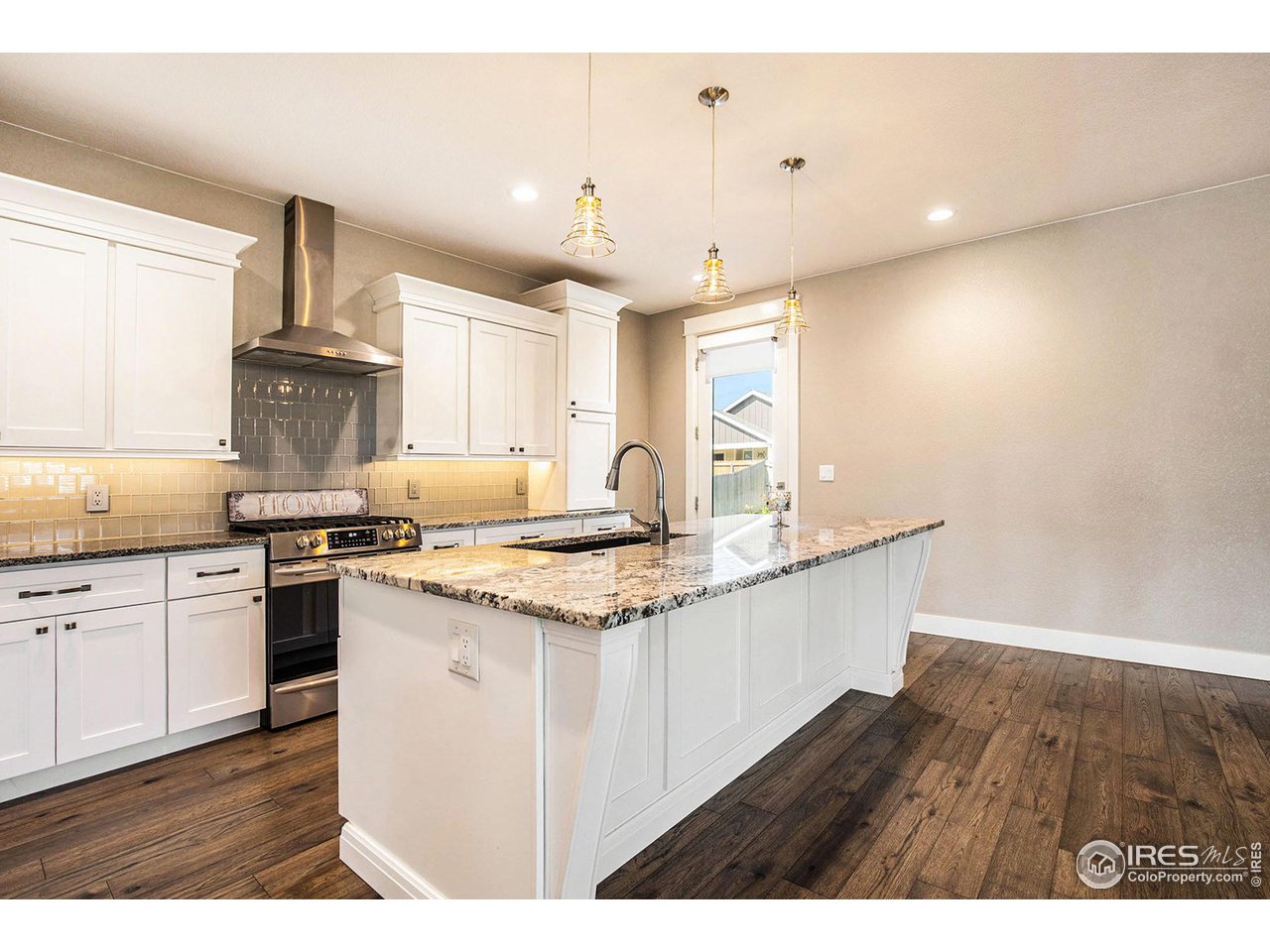 1100 Johnson Street Wiggins, CO 80654 - Photo 8 of 34 a kitchen with granite countertop a sink stainless steel appliances and cabinets