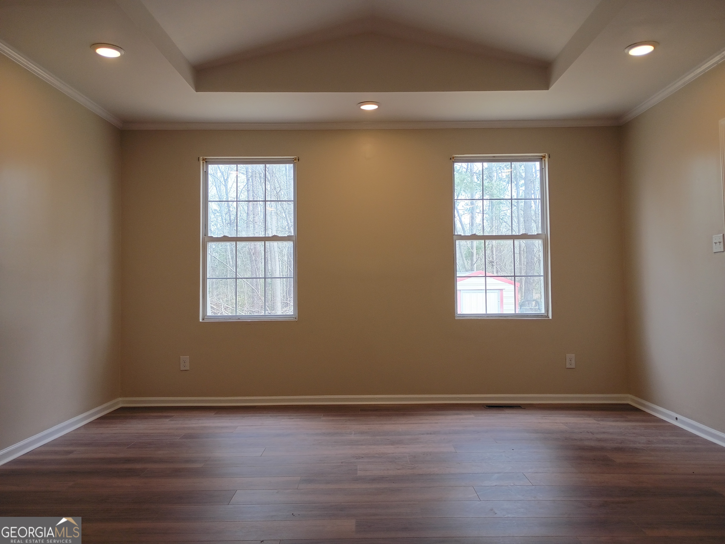 624 Thompson Road Swainsboro, GA 30401 - Photo 13 of 20 an empty room with wooden floor and windows