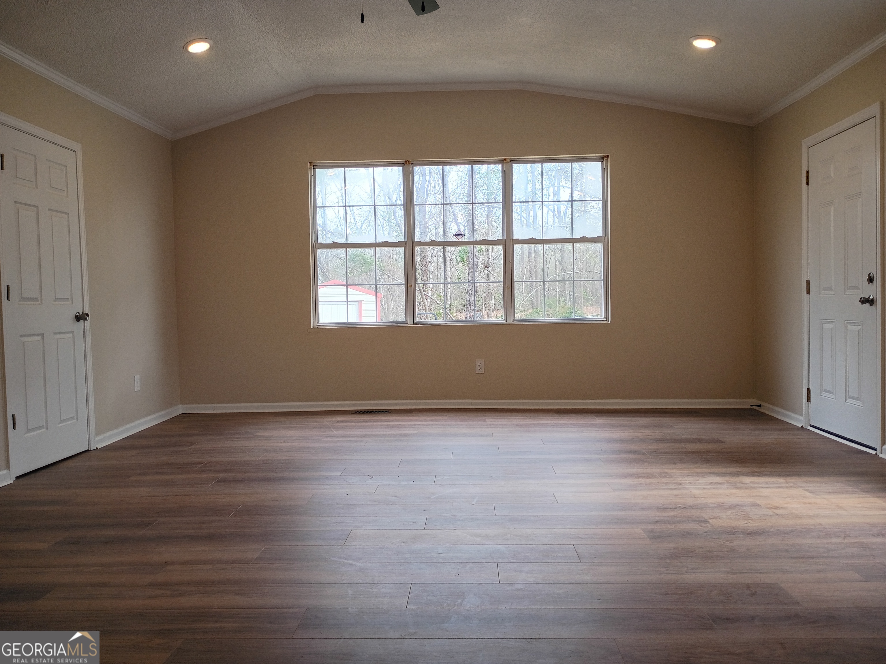 624 Thompson Road Swainsboro, GA 30401 - Photo 14 of 20 an empty room with wooden floor and windows