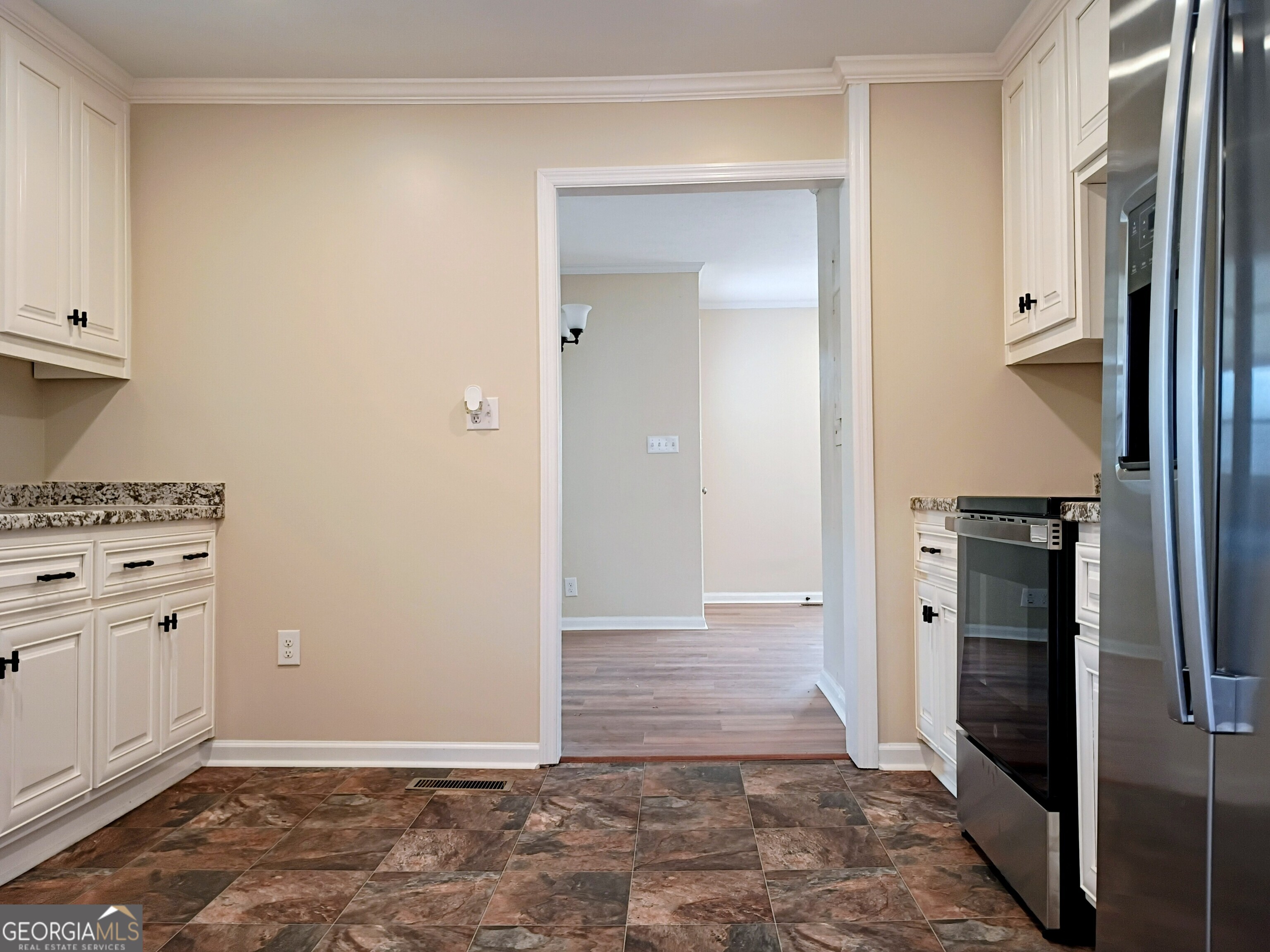 624 Thompson Road Swainsboro, GA 30401 - Photo 5 of 20 a view of a kitchen with refrigerator and white cabinets
